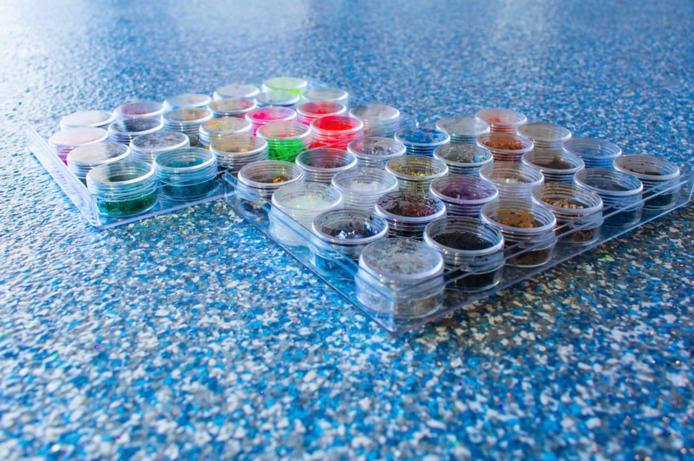 Tray of custom decorative flake color samples staged on a finished floor